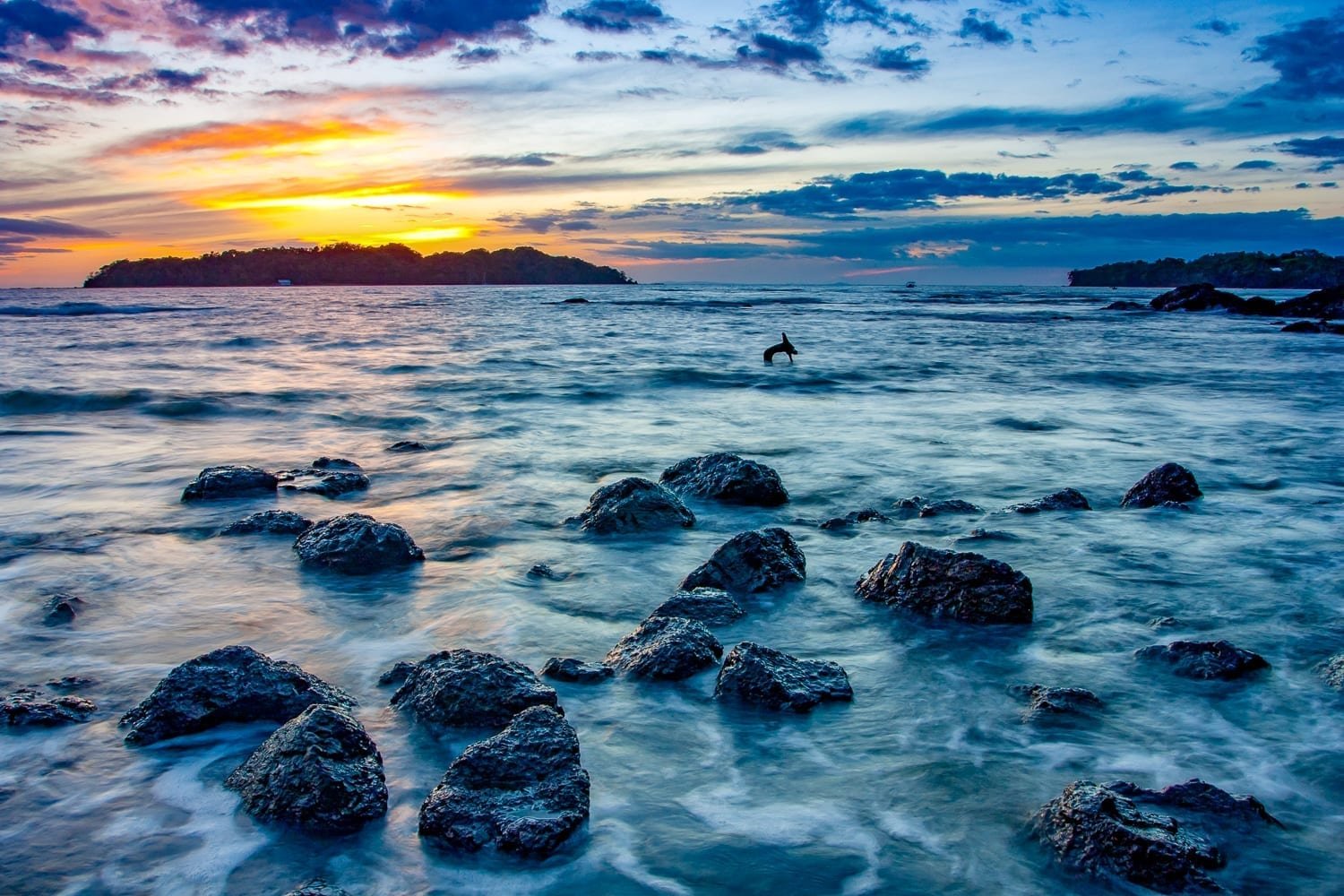 Panama-Vacatin-Travel-Santa-Catalina Rocky deep blue ocean with a fiery orange sunset in the background at Santa Catalina, Panama's beach