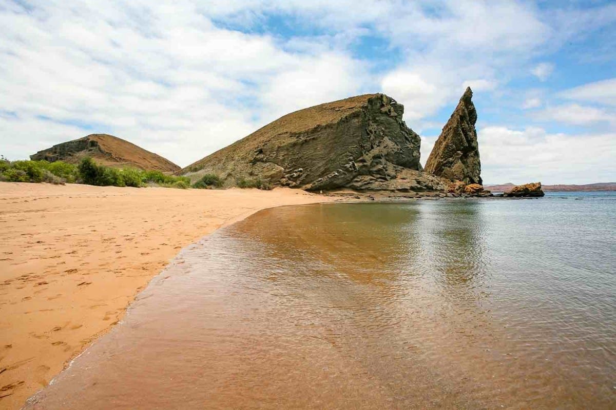 Private-Travel-Ecuador-Galapagos-Bartolome-Yellow-Beach Pristine sand beach with large rocks in background. Bartolome, Galapagos Islands