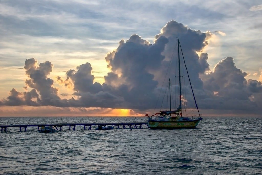 Belize-Private-Custom-Travel-Design-Ambergris-Caye-5 Charter sailboat moored at a dock in Ambergris Caye at sunset in Belize
