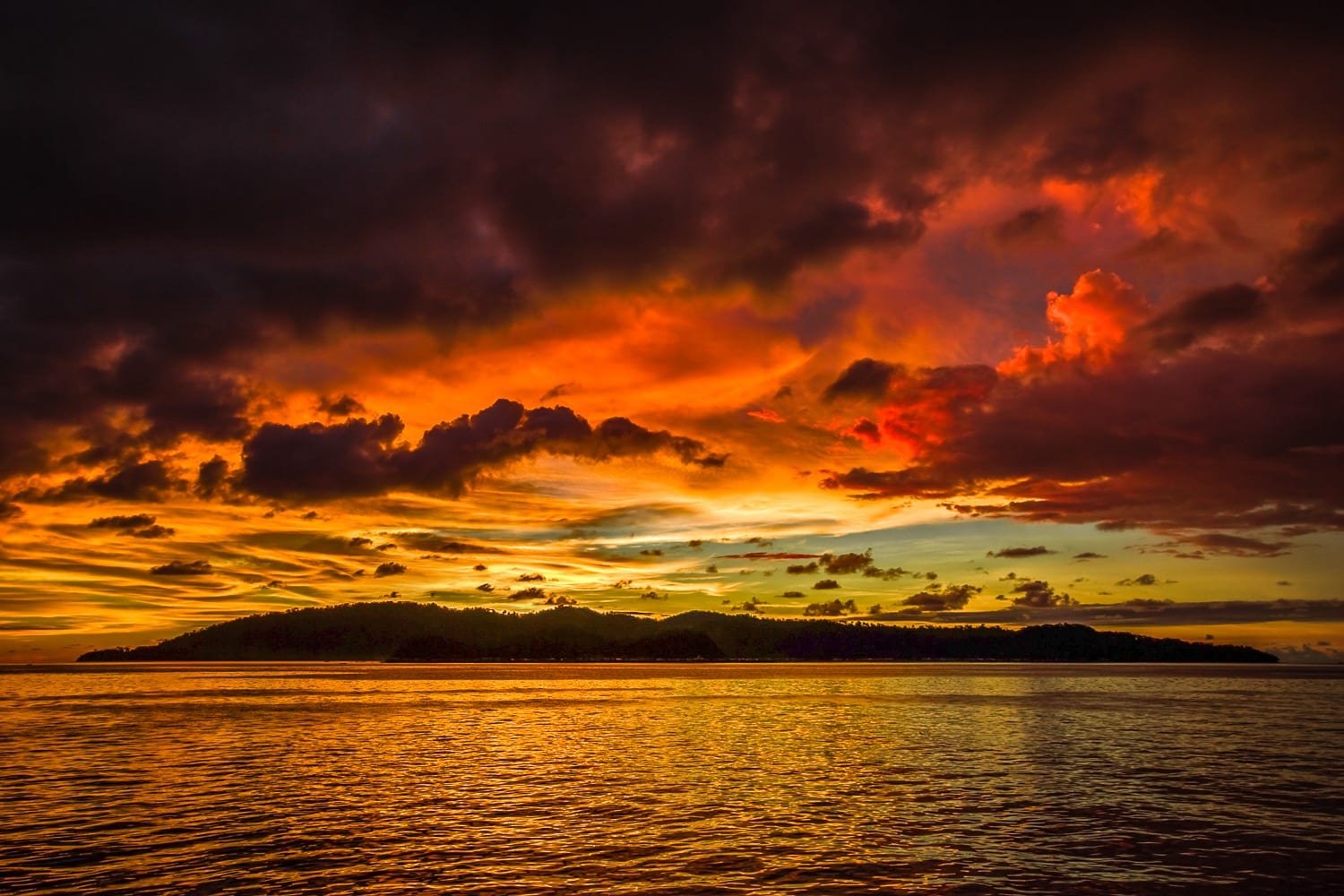 Belize-Private-Custom-Travel-Design-Sunset-2 A firey red and yellow sunset over the ocean, photographed on a family vacation to Belize