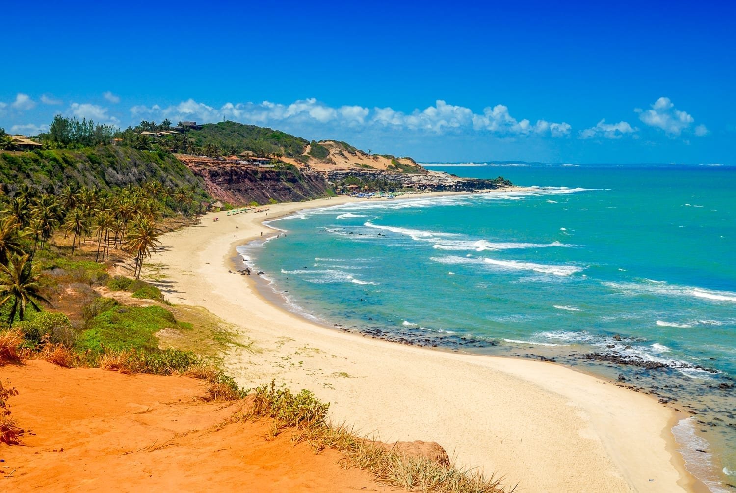 Brazil-Custom-Private-Travel-Pipa-Praia-do-Amor orange cliffs lining a white sandy beach with turqouise water, photographed on a helicopter tour of Brazil