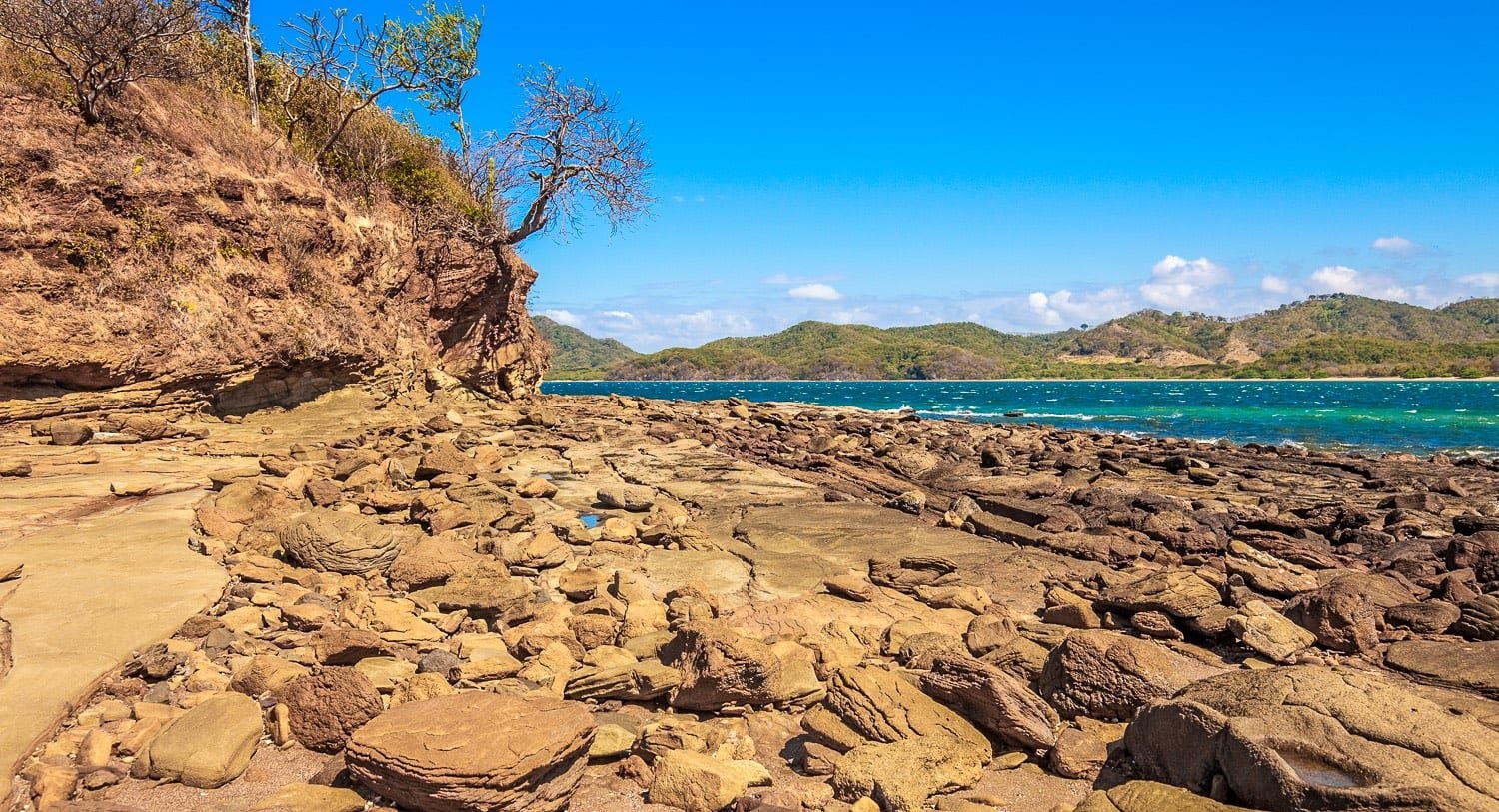 Costa-Rica-Custom-Private-Travel-Design-Northern-Nicoya-Rock-Shore Rocky tan shoreline of a beach in Northern Nicoya, Costa Rica
