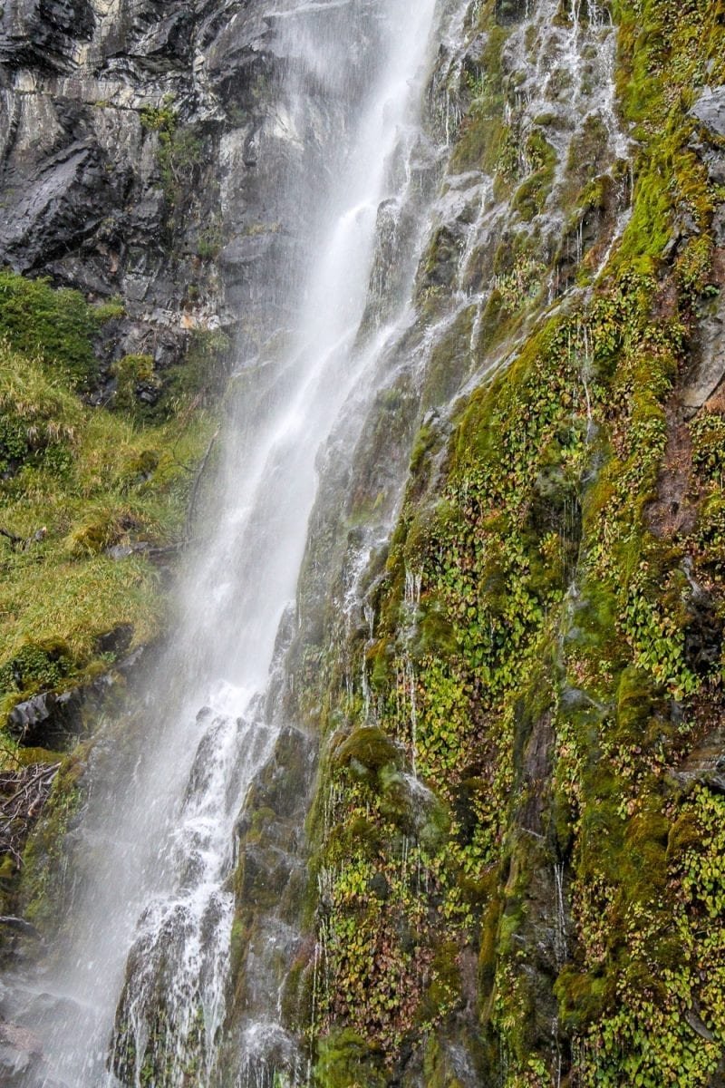 Custom-Travel-Argentina-El-Calafate-Waterfall Large waterfall cascading down lush green hill in Argentine Patagonia