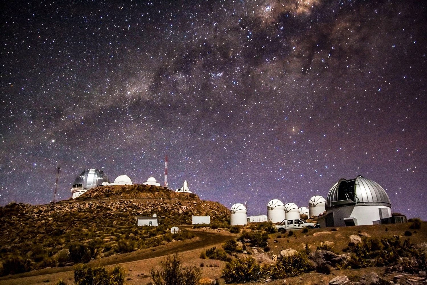 Custom-Travel-Private-Travel-Elqui-Valley-Observatories Majestic observatories of the Elqui Valley in Chile, backed by a purple night sky filled with bright stars and visible constellations