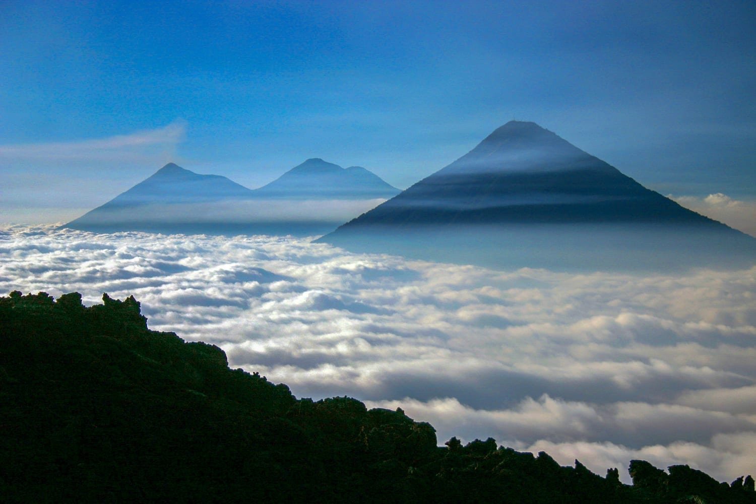The Cone of the Atitlan Volcano protruding over the clouds over the lake. Chichicastenango and Atitlan volcanoes emerging from Mist