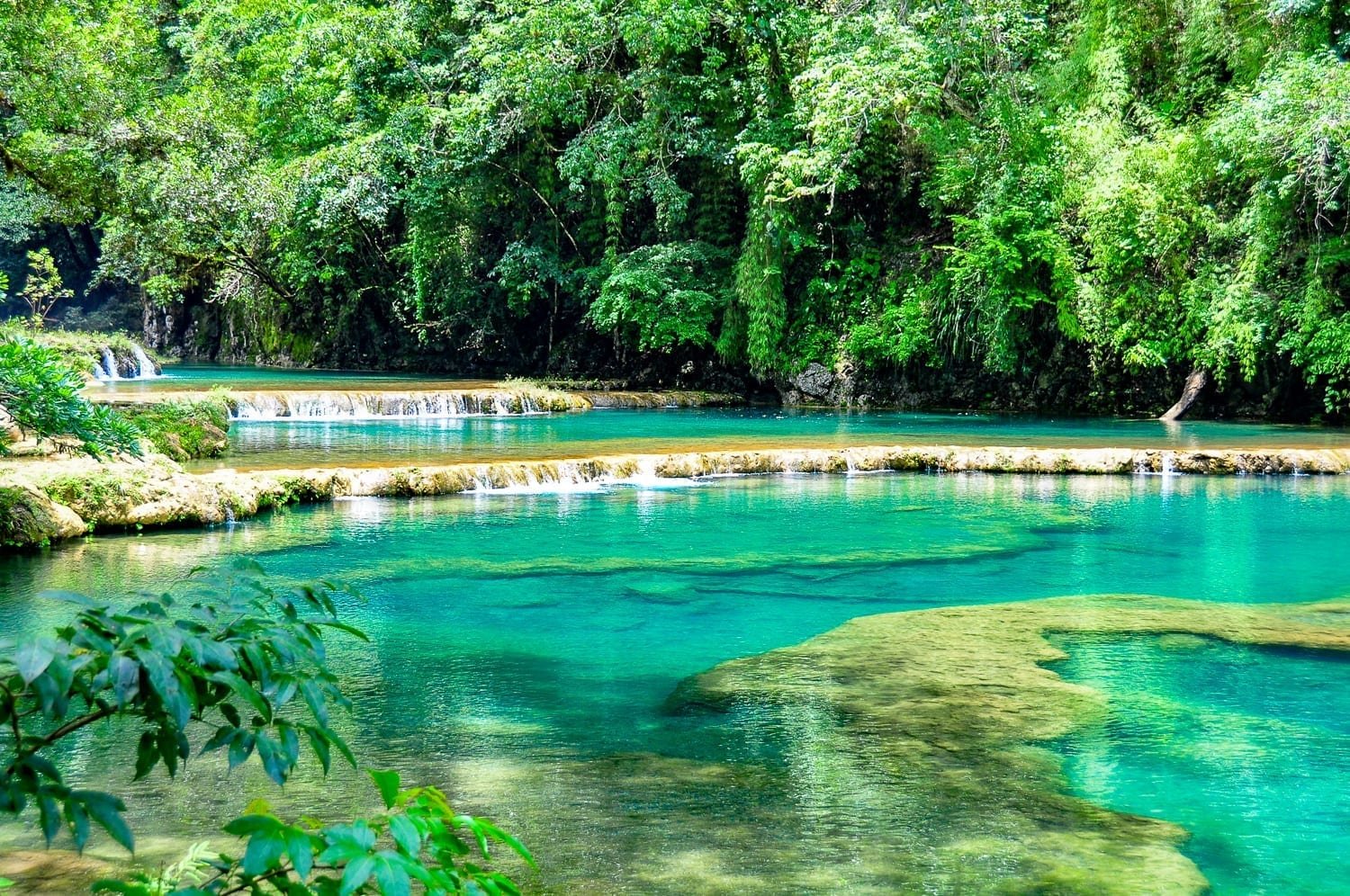 Guatemala-Private-Custom-Travel-Design-Semuc-Champey-2 The light blue waters of Lake Lachua in Las Verapaces, resemblent of the ocean near the caribbean and backed with dense green cloud forest