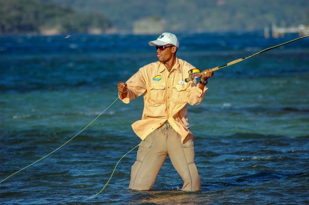 Honduras-Private-Custom-Travel-Design-Bay-Islands-Roatan-Flats-Fishing Man in a yellow fishing shirt fly fishing in the shallows of Roatan, Honduras