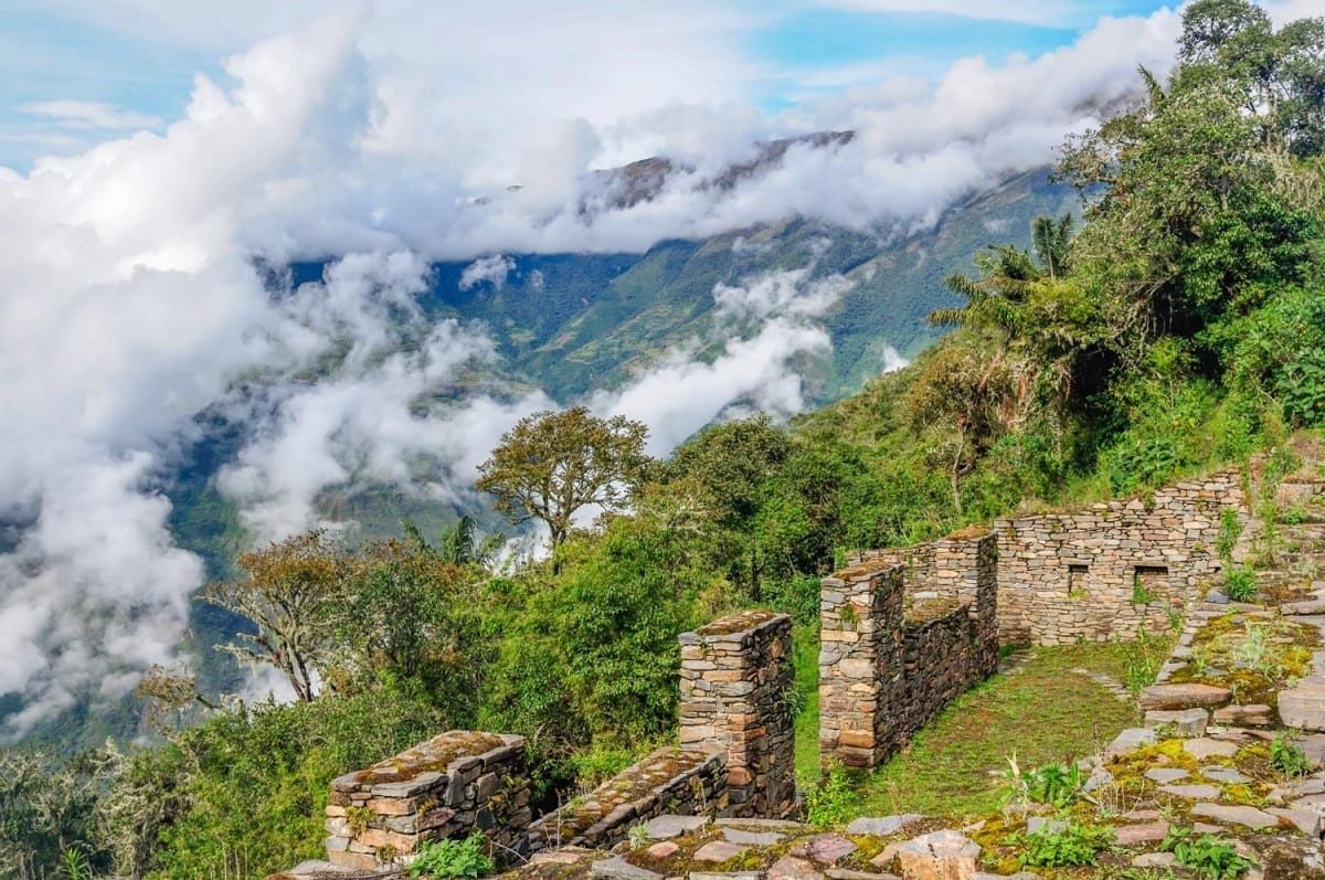 Landed-Travel-Private-Travel-Choquequirao-15-Peru Choquequirao ruins sitting on the mountainside, partially shrouded by clouds in Peru