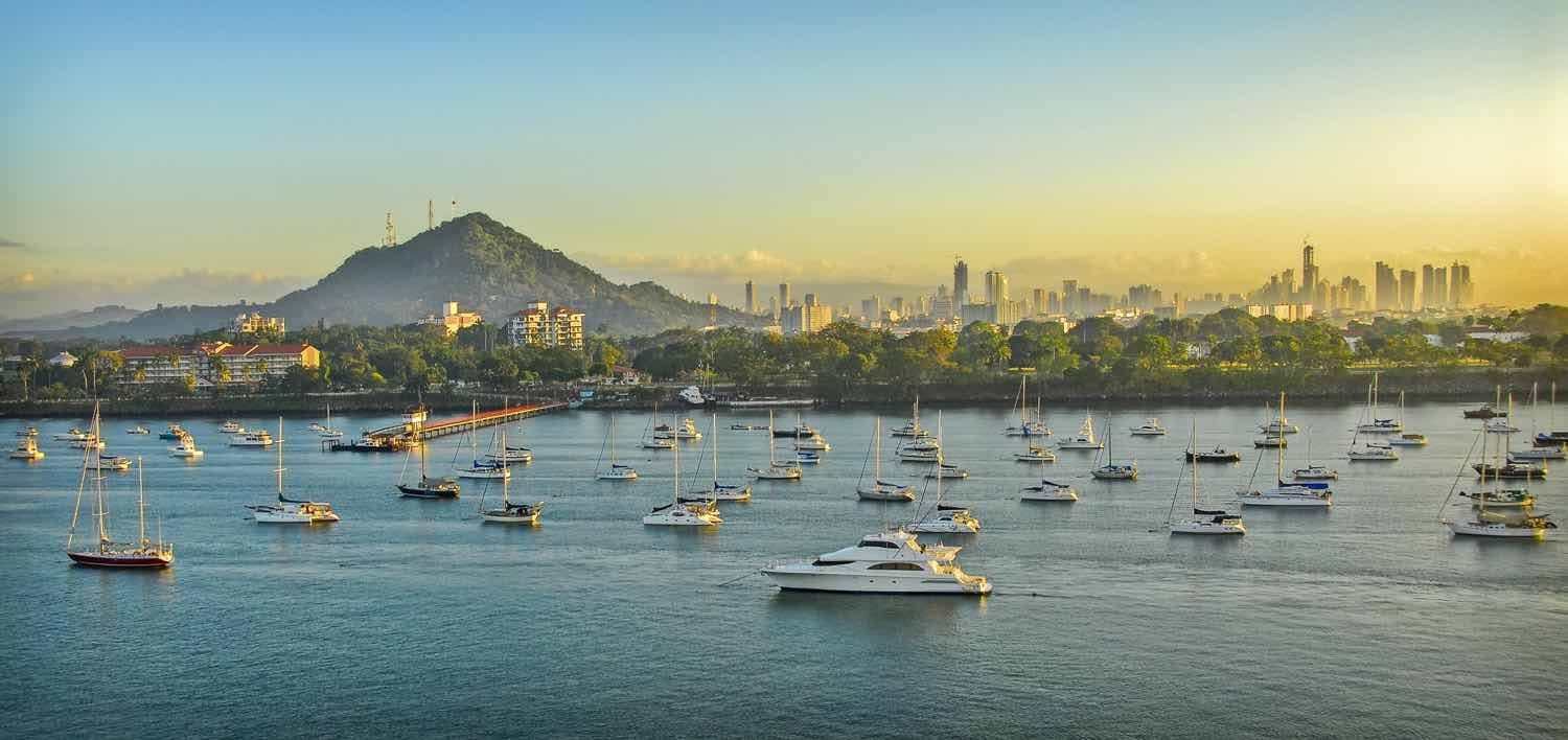 Landed-Travel-Private-Travel-Panama-City-Waterfront-Panama Charter yachts, fishing boats and catamarans dotting the waterfront off the coast of Panama City, Panama. Mountains and sunset in background