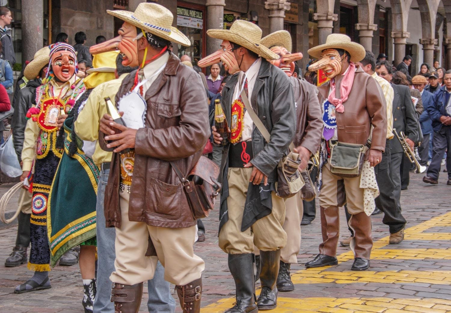 Landed-Travel-Private-Travel-Paucartambo-2-Peru Men in celebratory long-nosed wooden masks walking town the street in Paucartambo, Peru