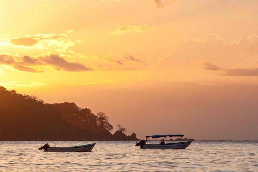 Isla-Santa-Catalina-Panama-Pacific A fiery orange sunset with heavy clouds over Panama's Isla Santa Catalina, two fishing boats in the water