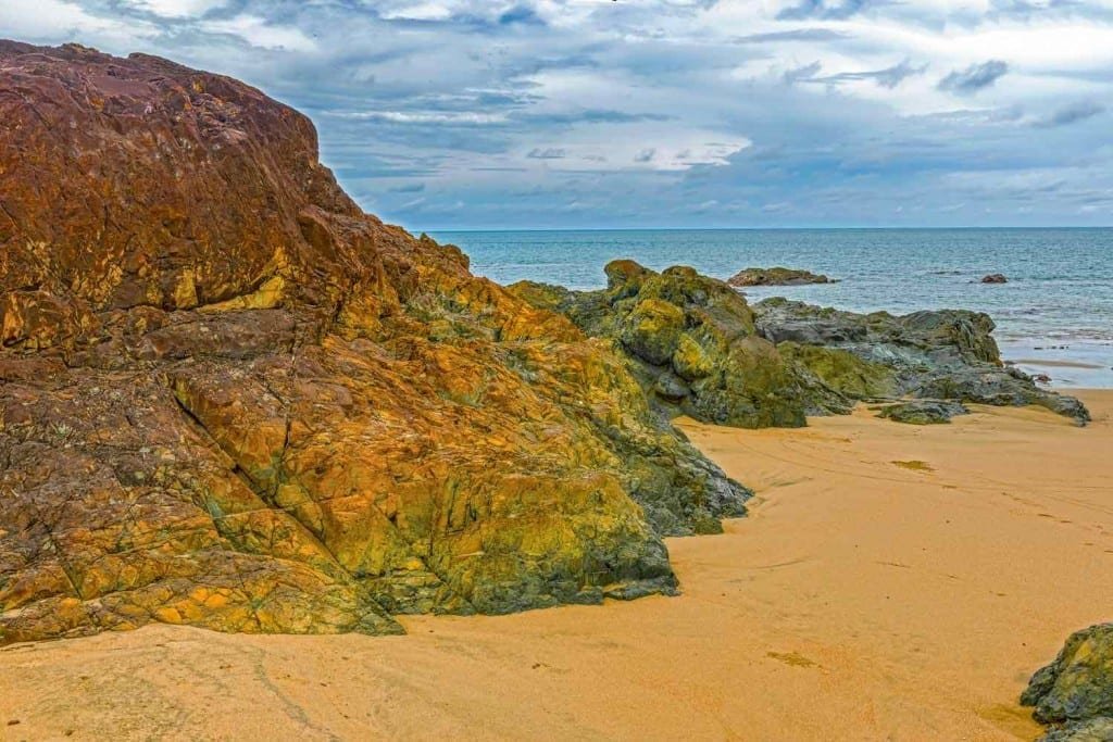 Pedasi-Azuero-Panama-Private-Travel Pedasi. Brown sand with reddish-brown rock formations overlooking the calm, light blue ocean Azuero Peninsula, Panama