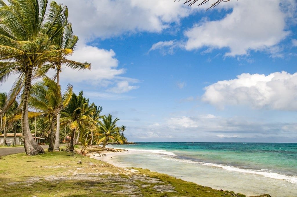 Private-Custom-Experiential-Travel-Nicaragua-Corn-Islands-Beach Palm-lined brown sand beach with caribbean blue ocean in corn islands Nicaragua on a family vacation