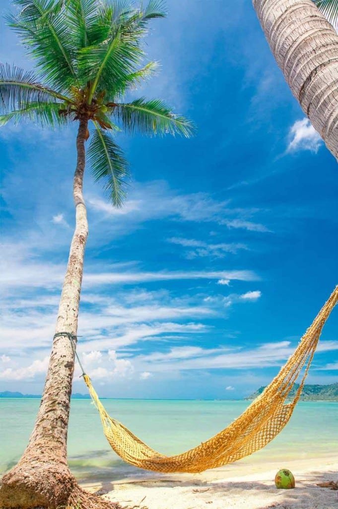 Private-Custom-Travel-Design-Pearl-Islands-Hammock A yellow hammock strung between two palms on a perfect white sand beach overlooking the Caribbean Sea on a family vacation to the Pearl Islands