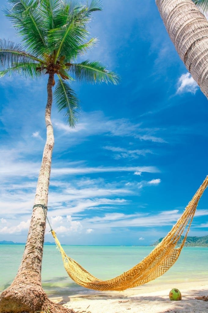 Private-Custom-Travel-Design-Pearl-Islands-Hammock A yellow hammock strung between two palms on a perfect white sand beach overlooking the Caribbean Sea on a family vacation to the Pearl Islands
