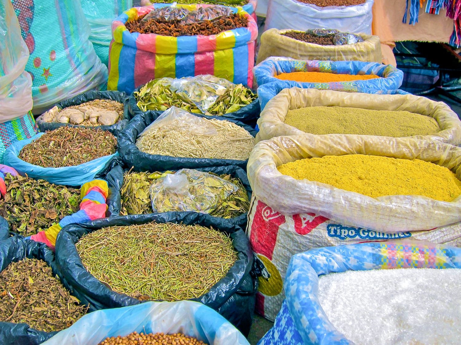 Private-Travel-Ecuador-Otavalo-Market-Spices Colorful bags of spices on display at traditional Otavalo Market in Ecuador