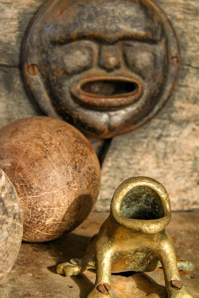 Custom-Travel-Cordoba-Sapo-Game-Estancia Ancient indigenous round brown mask and golden frog sculpture in Argentina