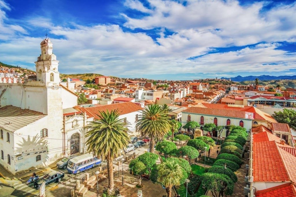 Landed-Travel-Private-Travel-Old-Town-Sucre-Bolivia Aerial shot of old town Sucre, Bolivia, Red clay roofs and white colonial buildings with palm trees sprinkled throughout