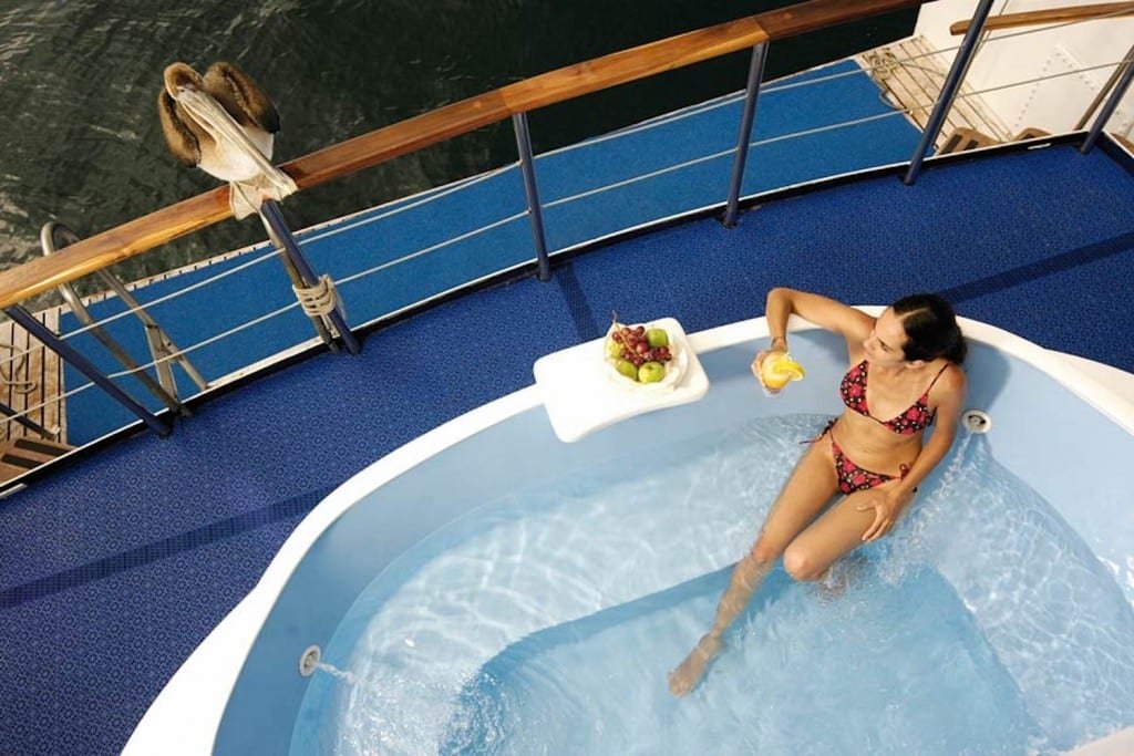coral-galapagos-yacht-pool Woman in hot tub on deck of Coral I Galapagos Charter Yacht enjoying cocktail and fruit