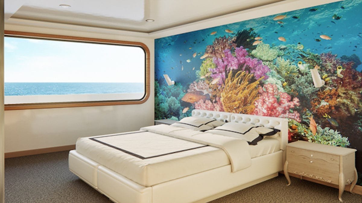 Camila-Trimaran-Charter-Galapagos-5 Cabin onboard Luxury Galapagos Island Catamaran Charter vessel, Camila Trimaran, showing white luxury linens and unique mural of coral reef with large ocean view window