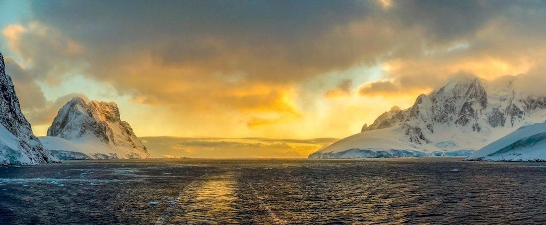 Landed-Travel-Private-Travel-Lemaire-Channel-Golden-Antarctica Sunset over the ocean photographed in Antarctica
