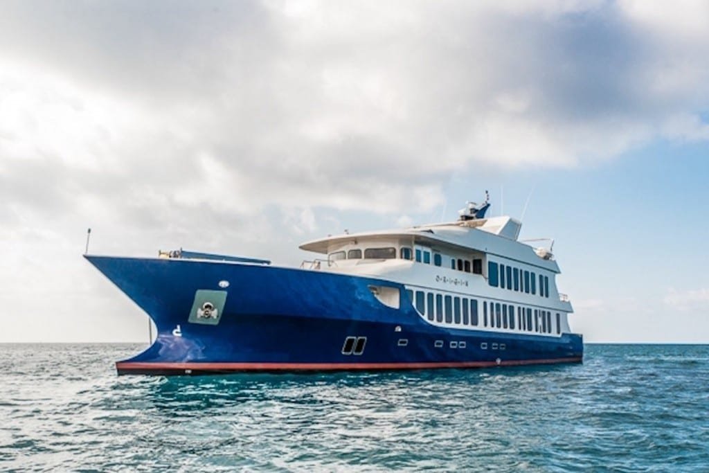 Origin-Yacht-Charter-Galapagos-1 M/V Origin Galapagos Island Charter Yacht. Large blue yacht with white accents cruising the Galapagos Archipelago