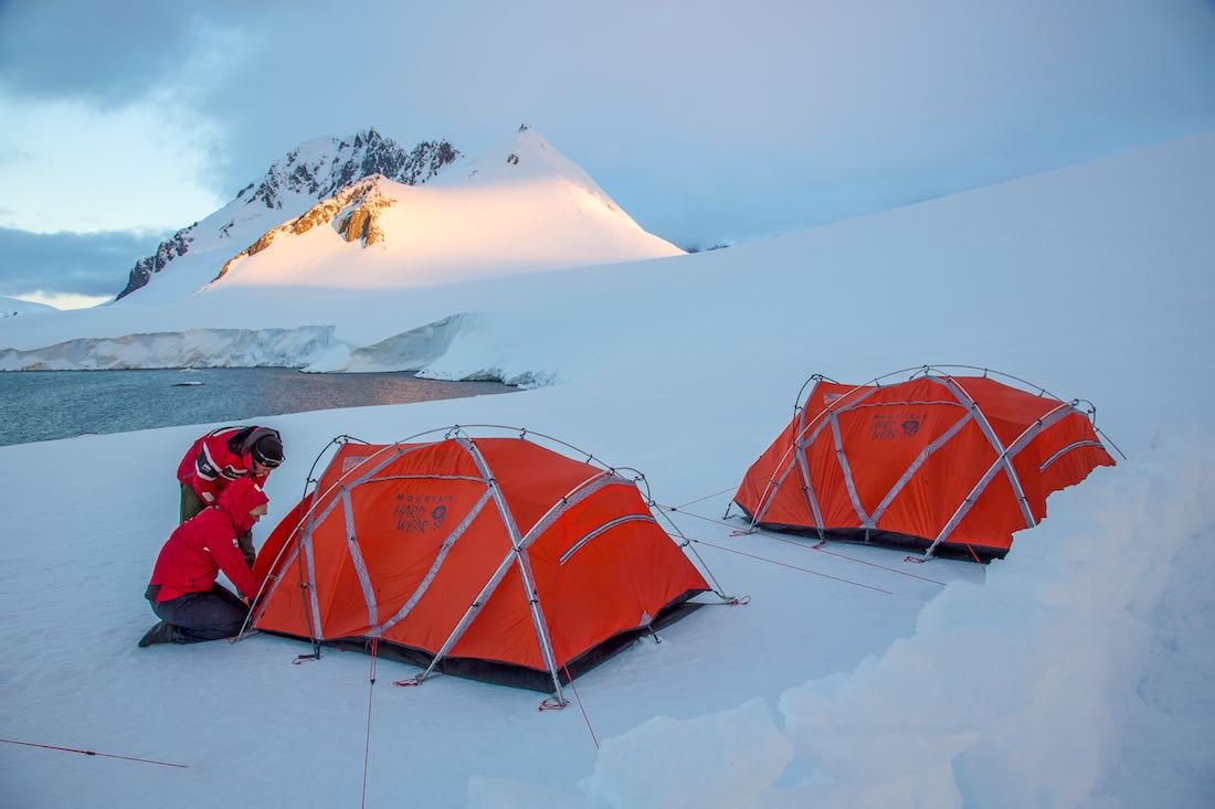 Antarctica-Private-Custom-Travel-Design-Cruise-Polar-Latitudes-32 Two people getting into a red tent next to another red tent an Antarctica hotel alternative camp