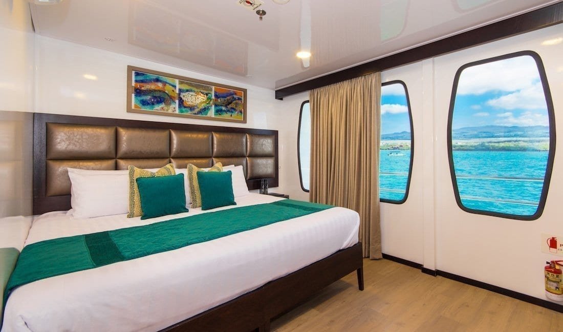 alia-double-cabin-1 Large bed with luxury linens and oceanview windows onboard Alya luxury Galapagos charter catamaran