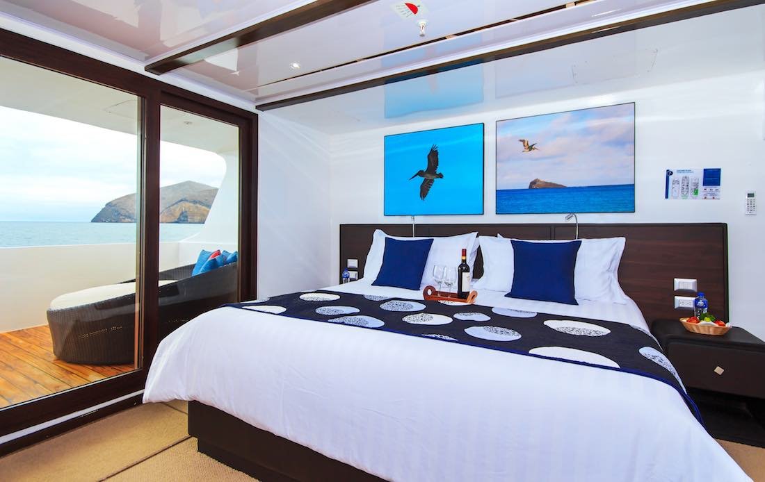 natural-paradise-galapagos-charter-yacht-suite Large bed with white luxury linens onboard cabin onboard Galapagos Yacht Charter Natural Paradise