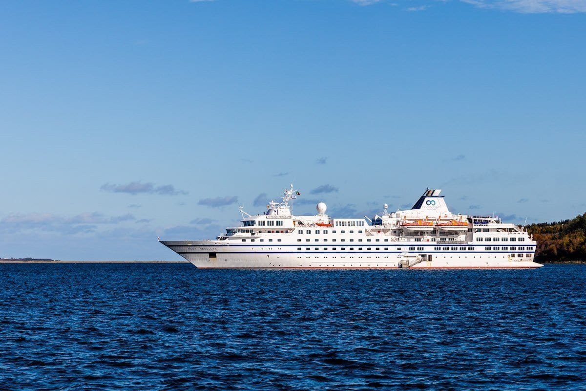 _19A7616 Roger Pimenta One Ocean Expeditions have a large RCGS ship is white and has multiple decks and windows.