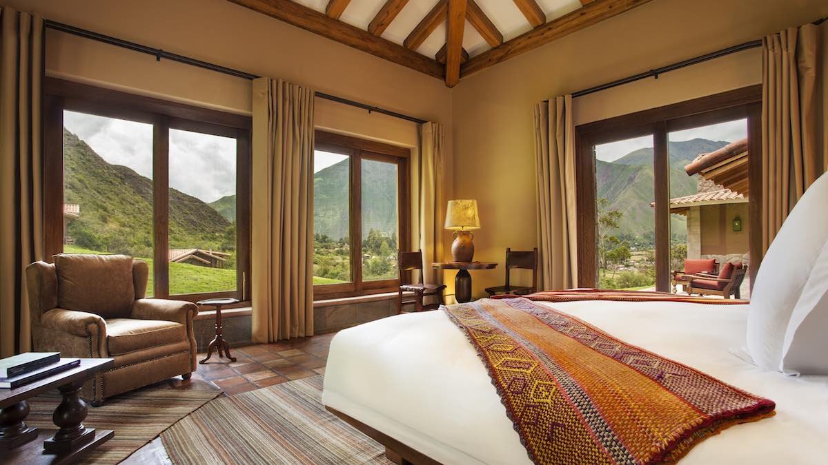 Hacienda-Urubamba-Jr-Suite Hacienda Urubamba suite showcases green mountain views, large windows, and a king size bed.
