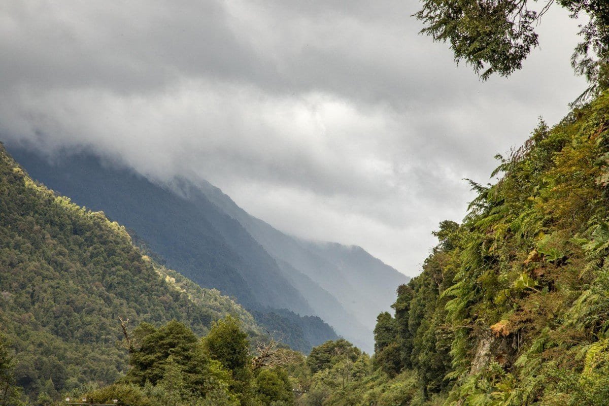 Private-Travel-Chile-Aysen-214 Steep, lush green valley stretching for miles through Patagonia in Chile with a dense fog overhead