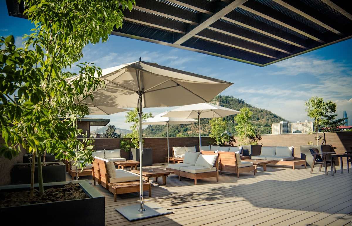 Roof-Top-Lounge-Singular-Santiago The Singular Santiago Hotel has a rooftop sun deck equipped with umbrellas, lounge chairs and shaded trees that overlook Chile's downtown area.