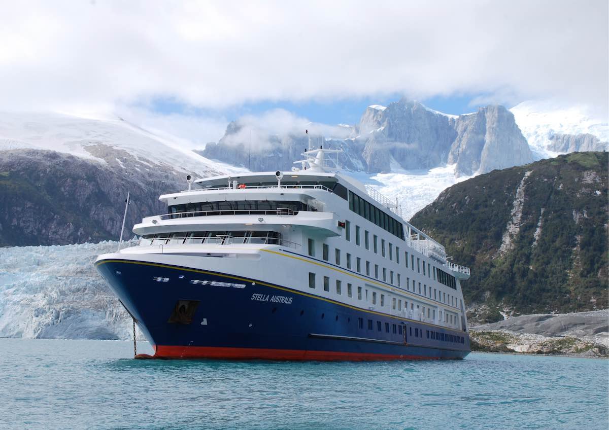 Stella-Australis-Exterior The Stella Australis ship travels through ice blue water with snow capped mountains in the exterior.