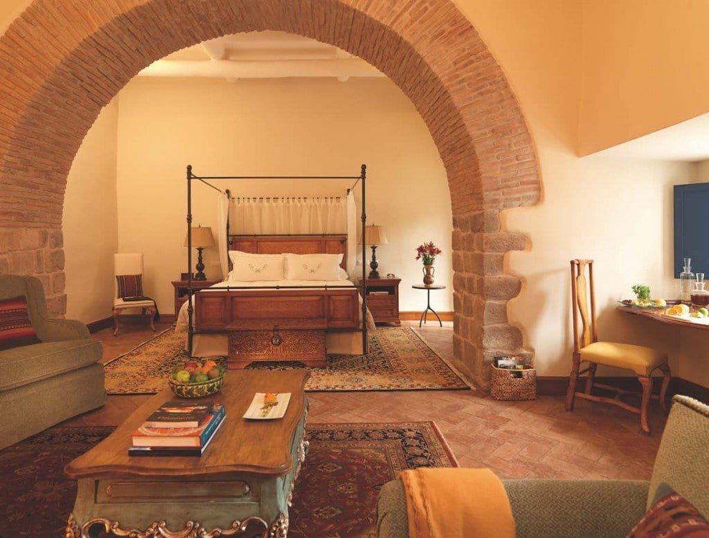 Belmond-Nazarenes-Signature-Suite-Adrian-Houston The signature suites at Belmond Palacio Nazarenas feature a large brick archway that leads to a four poster bed, living area and furnishings.