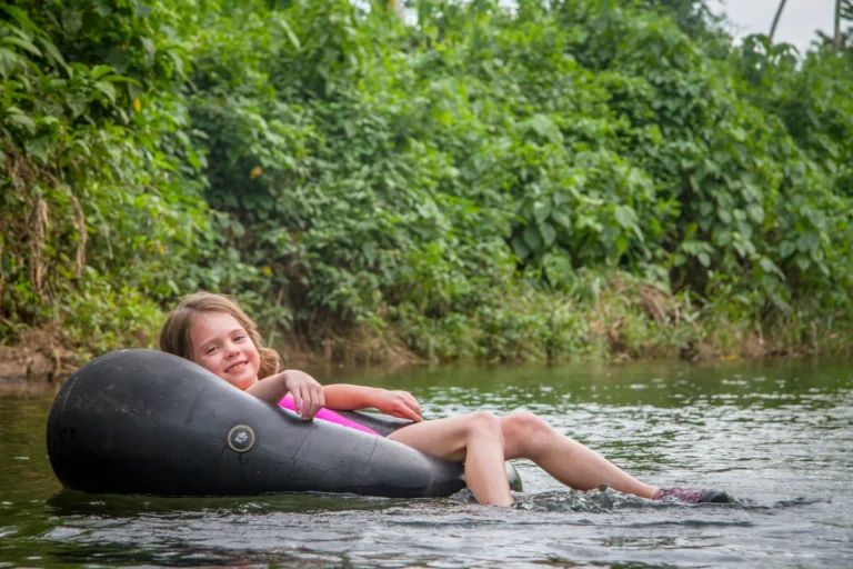 A girl floats on a tube on a river in Mountain Pine