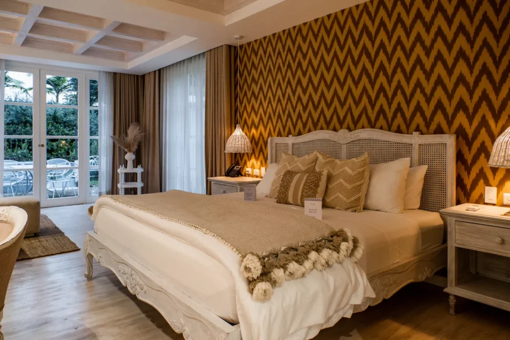 Luxury suite bedroom with king bed and wooden floors at Villa Bokeh