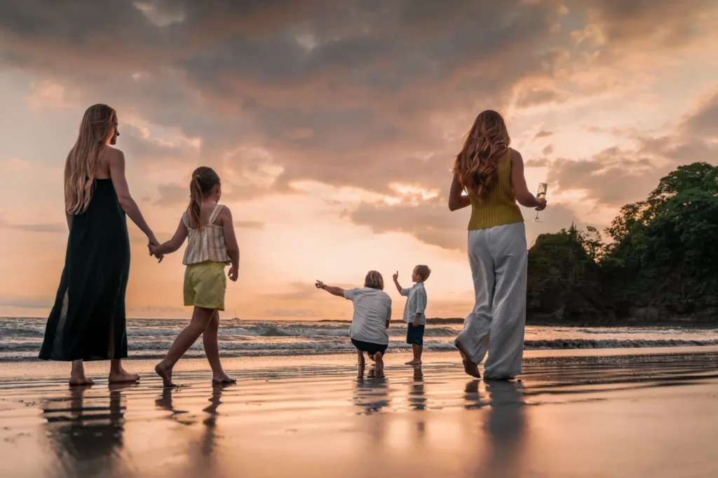 Family walking in the beach in Costa Rica looking at the sunset