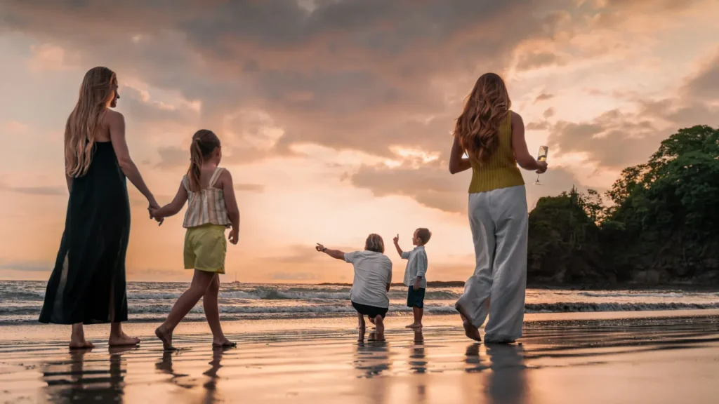 Family walking in the beach in Costa Rica looking at the sunset